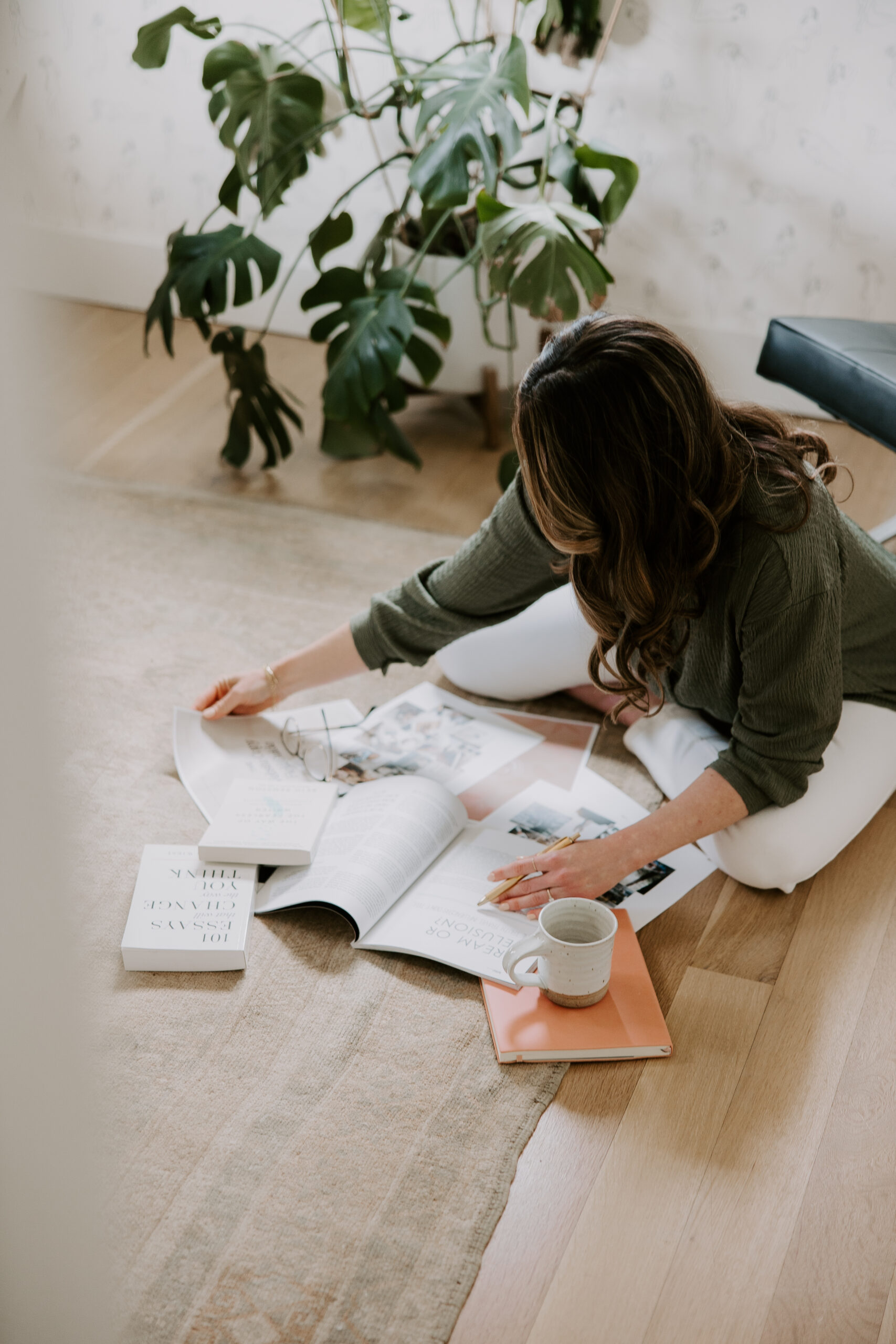 A website copywriter sitting on the floor with a mood board and magazine