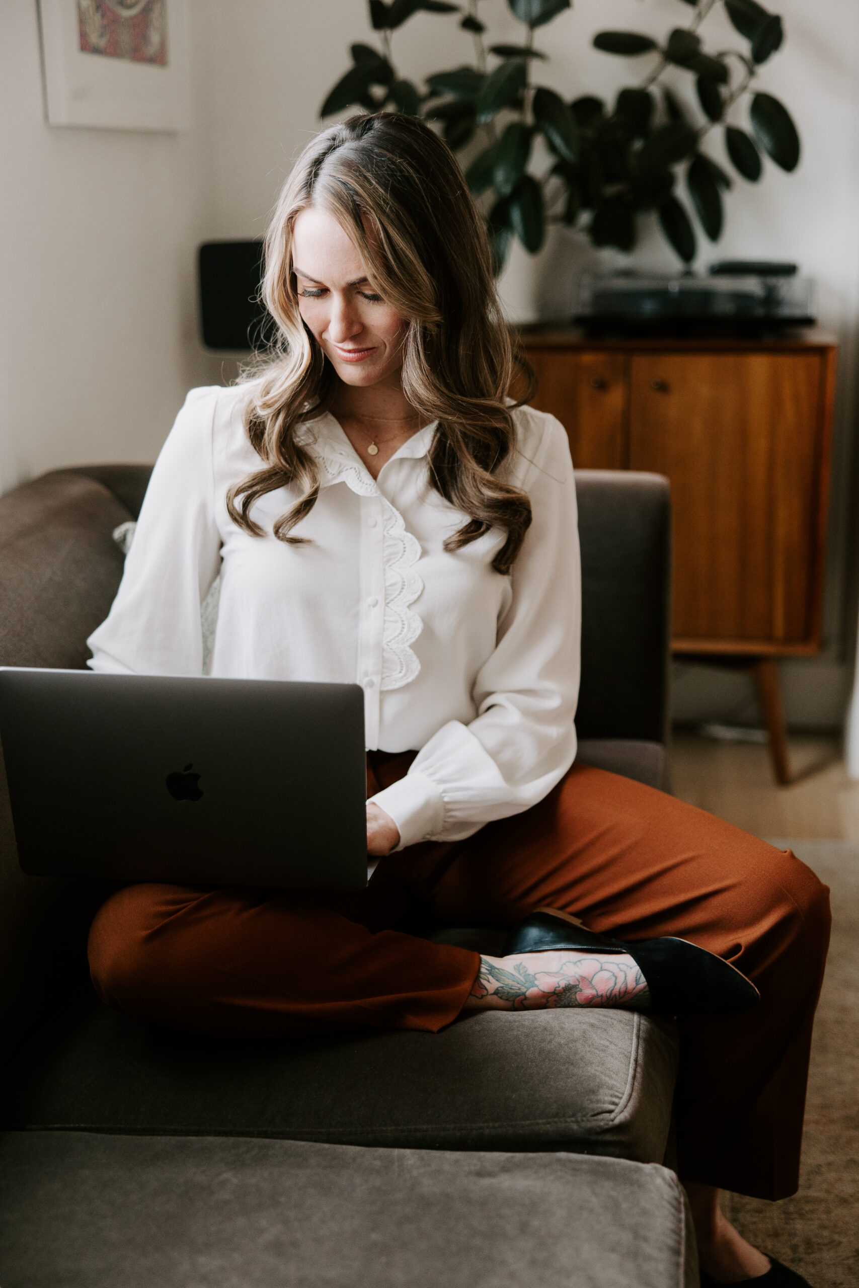 A website copywriting sitting on a couch with a MacBook