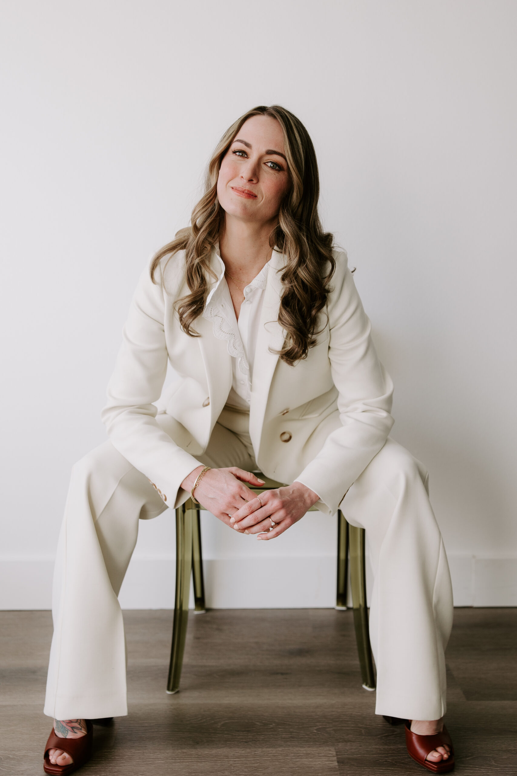 SEO website copywriter Erika Fitzgerald wearing a white suite and sitting in a chair